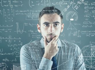 A man reading mathematical formulas from a blackboard inquisitively